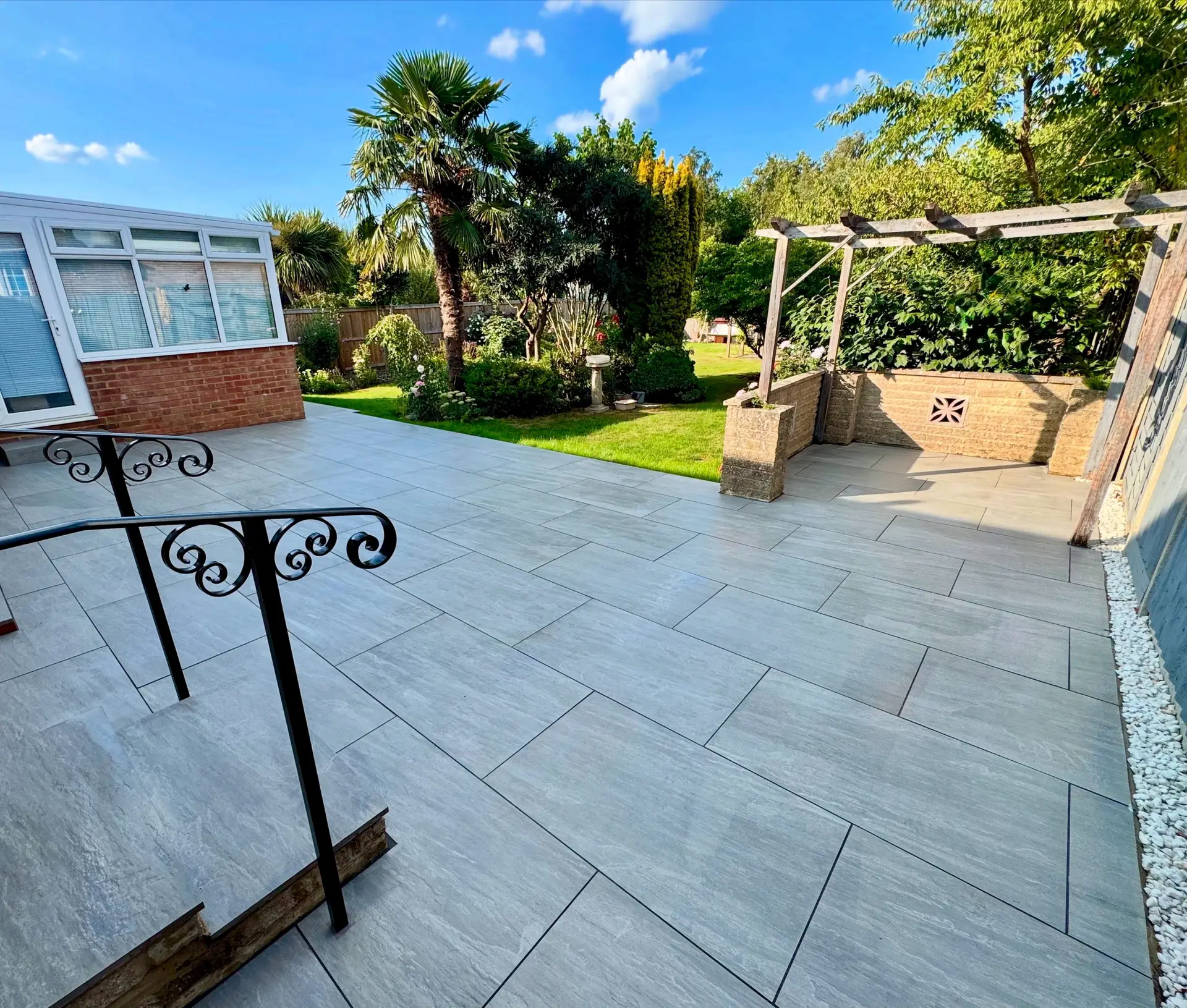 A multi-level Sussex garden with porcelain zoning and an outdoor kitchen