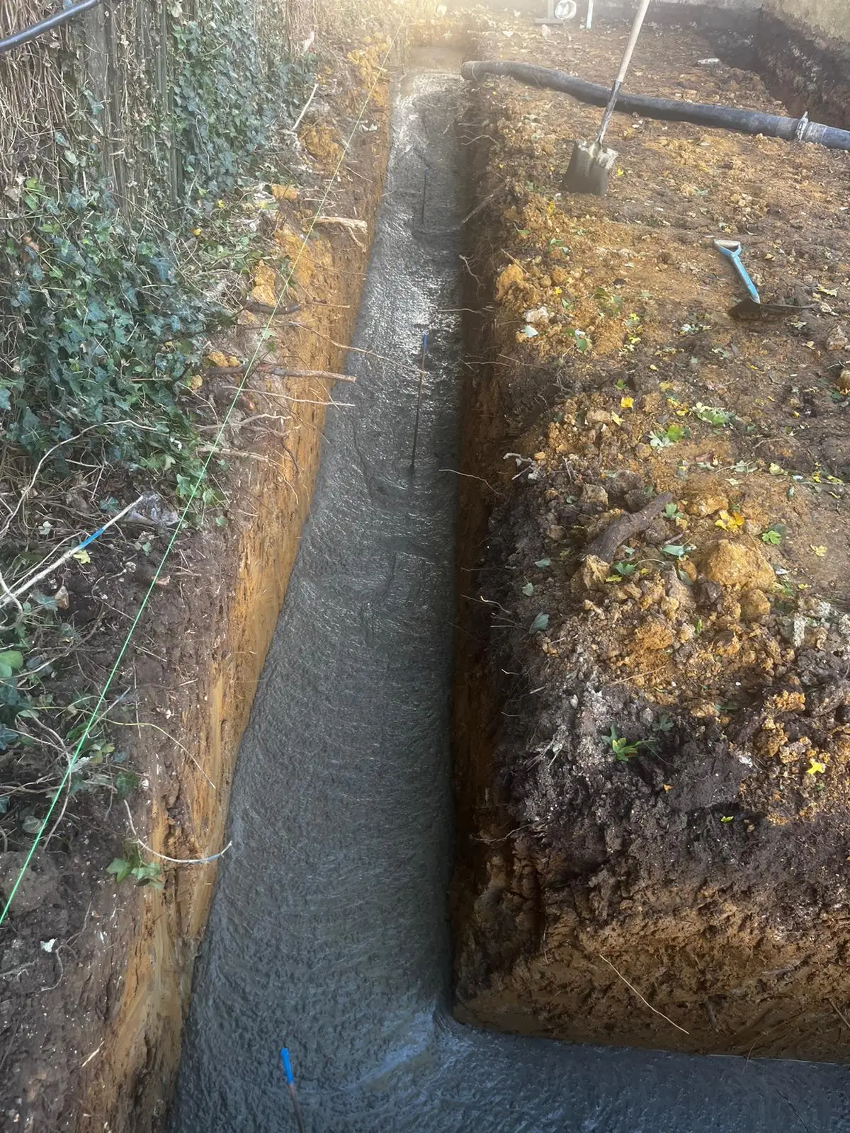 A clean foundation trench in a Hastings garden, demonstrating careful groundworks that protect spring landscaping.