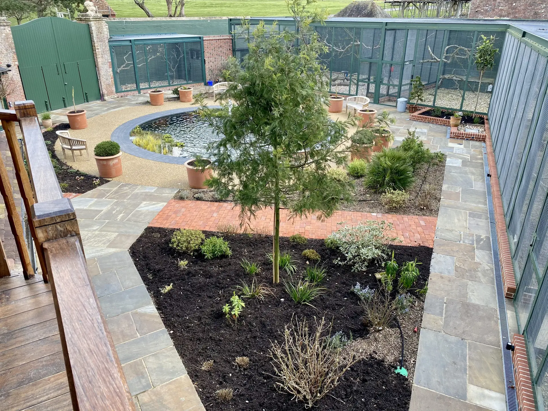 Professional landscaping in Kent showing a multi-layered spring garden bed with native plants and a gravel path.