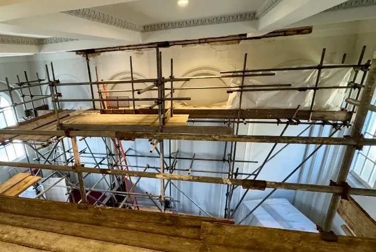 A close-up of high-quality brickwork and a sturdy steel lintel being installed above a doorway.